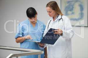 Female doctor explaining notes to nurse