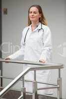 Female doctor proudly standing on the top of the stairs