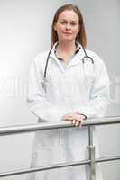 Female doctor standing against railing