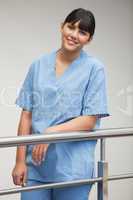 Nurse smiling while leaning against railing