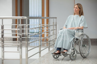 Woman sitting in wheelchair in hospital corridor