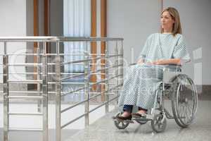 Woman sitting in wheelchair in hospital corridor