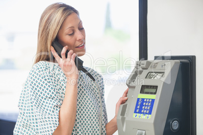 Female patient using payphone