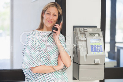 Smiling patient using payphone