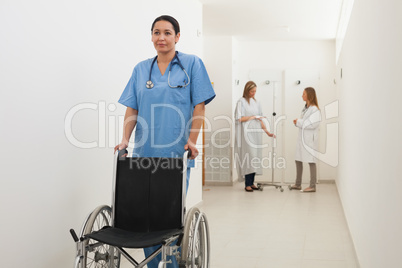 Nurse pushing empty wheelchair