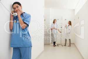 Nurseusing payphone with doctor talking to patient