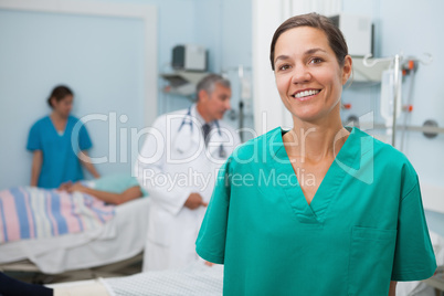 Nurse is standing hospital room and smiling