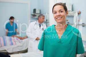 Nurse is standing hospital room and smiling