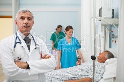Doctor with folded arms in hospital room