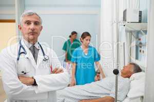 Doctor with folded arms in hospital room