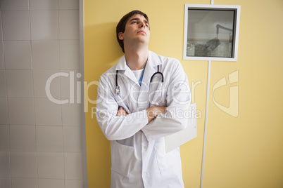 Tired doctor standing hospital room