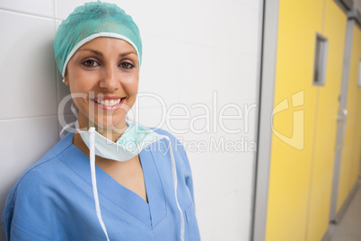 Smiling nurse leans against wall