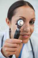 Doctor looks through otoscope