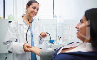 Doctor checking patients blood pressure