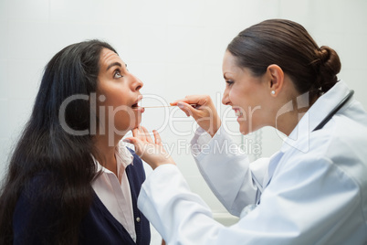 Smiling doctor looking into patients mouth