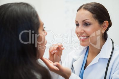 Woman's mouth being examined by happy doctor