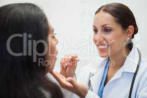 Woman's mouth being examined by happy doctor