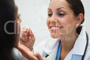 Doctor is looking into the mouth of the woman with an instrument