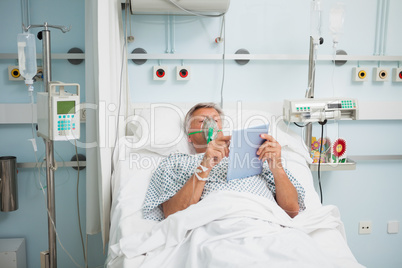 Patient lying in bed wearing oxegen mask