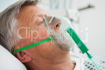 Man in bed with oxygen mask