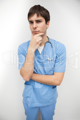 Male nurse is thinking with chin in hand