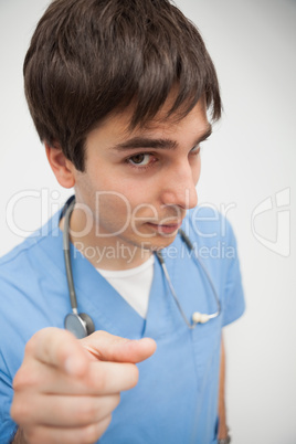 Male nurse is pointing at camera