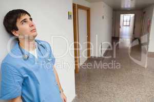 Distressed nurse leaning on wall