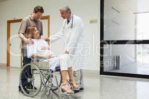 Pregnant woman in wheelchair talks to doctor