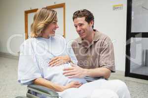 Pregnant woman in wheelchair talking with partner