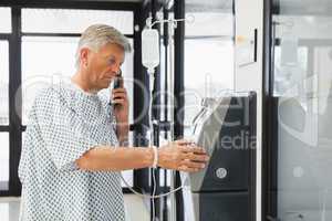 Man with I.V drip using pay phone