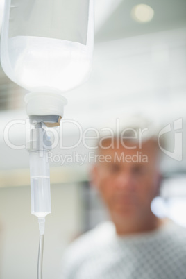 Intravenous drip with patient in background