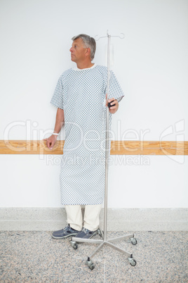 Man standing against the wall with his IV drip