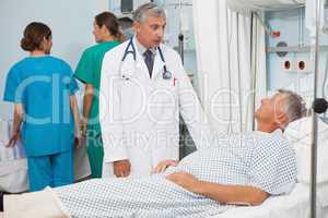 Patient  lying in bed talking to  doctor
