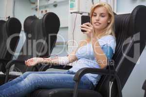 Blonde woman relaxing in a chair while getting dialysis