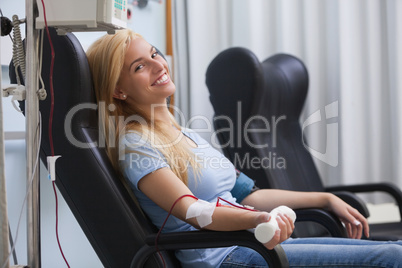 Smiling woman donating blood