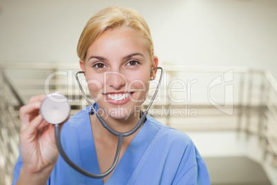 Smiling nurse showing her stethoscope