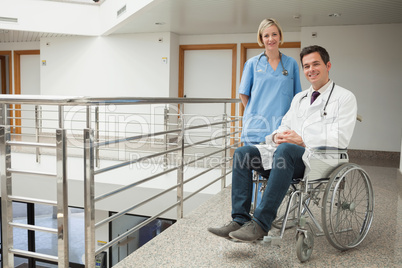 Nurse standing with doctor sitting in wheelchair