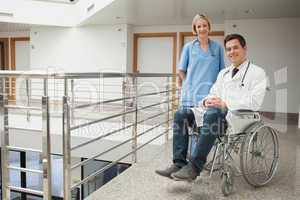 Nurse standing with doctor sitting in wheelchair