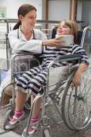 Female doctor adjusting childs neck brace in wheelchair