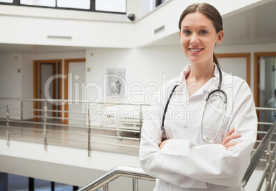 Female smiling doctor standing at the stairwell
