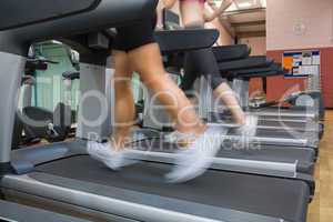 Two people running on treadmills in the gym