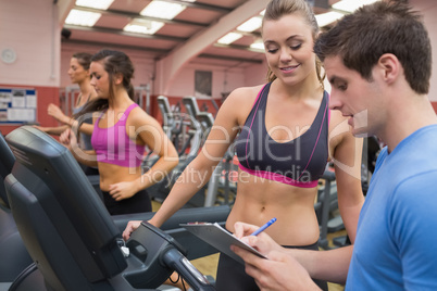 Trainer helping a woman in a gym