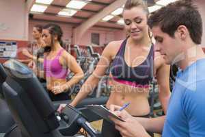 Trainer helping a woman in a gym