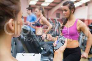 Instructor using stopwatch in gym