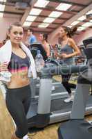 Woman in gym beside treadmill