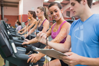 Instructor showing stopwatch in gym