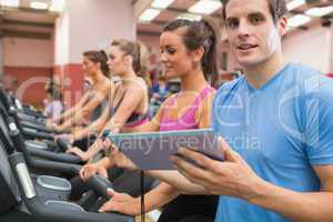 Male gym instructor with women on treadmills