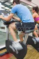 Man and woman riding on an exercise bike