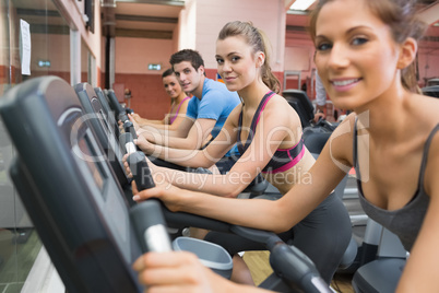 Four people working out on exercise bikes