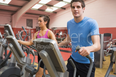 Woman and man training on a step machine